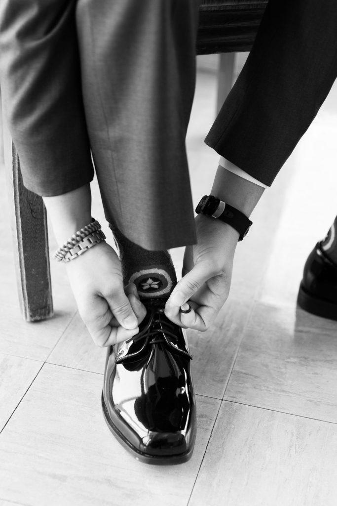 groom ties his shoes at Trinity Missionary Church in Yale, Michigan