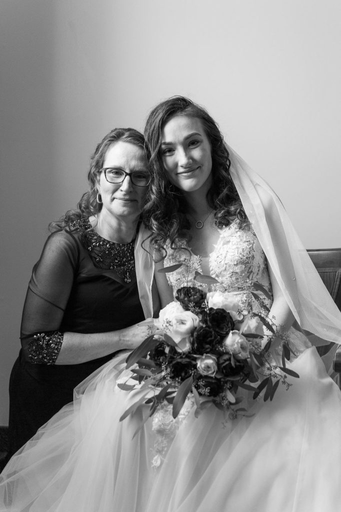 mom helps bride put on her wedding dress at Trinity Missionary Church in Yale, Michigan