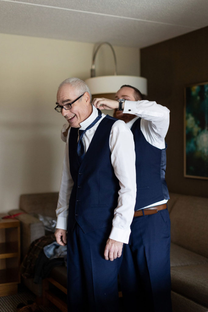 Groom putting on his tux during his Lansing Wedding photographed by Taylor Ingles Photography