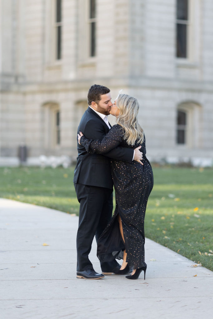 Engaged couple kissing during their engagement session at the Lansing Capitol Building